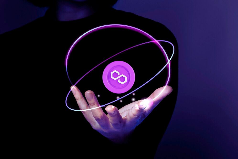 Mulher adulta segurando o logo da criptomoeda Polygon na palma da mão.